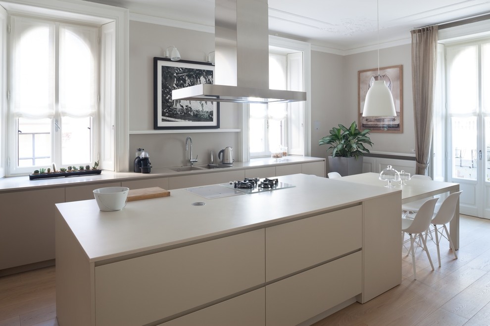 Idee per una grande cucina minimalista con lavello da incasso, ante lisce, ante beige, top in superficie solida, parquet chiaro e pavimento beige