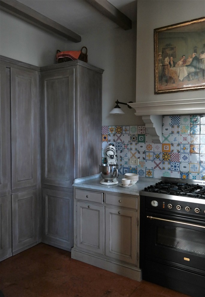 Foto på ett avskilt, litet lantligt u-kök, med en undermonterad diskho, luckor med profilerade fronter, marmorbänkskiva, stänkskydd i keramik och klinkergolv i terrakotta