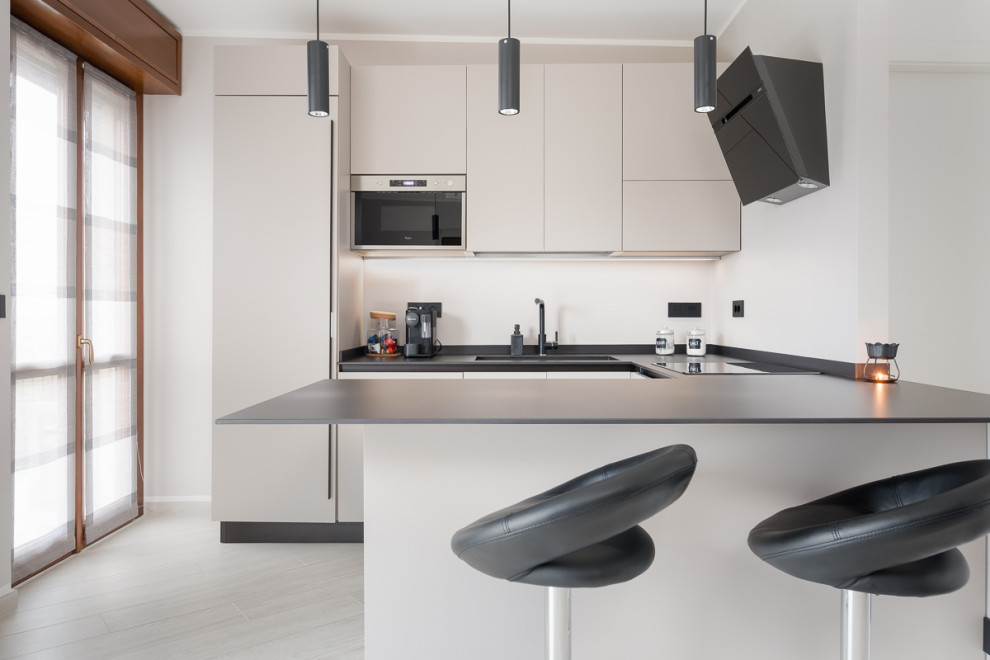 Foto di una grande cucina moderna con lavello integrato, pavimento in laminato e pavimento grigio