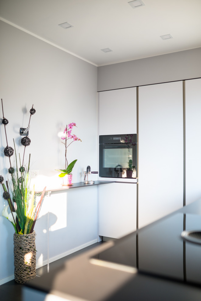 Esempio di una cucina minimalista di medie dimensioni con lavello a doppia vasca, ante grigie, top in laminato, pavimento in gres porcellanato, pavimento grigio e top grigio