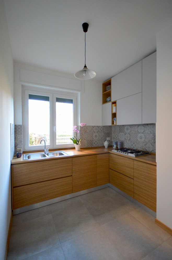 Example of a mid-sized trendy l-shaped kitchen design in Milan with a drop-in sink, flat-panel cabinets, light wood cabinets, wood countertops, multicolored backsplash and ceramic backsplash
