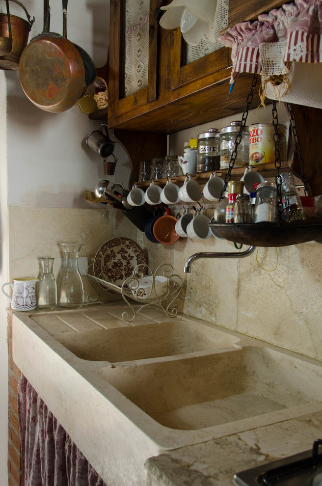 Foto på ett mellanstort shabby chic-inspirerat linjärt kök och matrum, med en rustik diskho, skåp i mörkt trä, bänkskiva i kalksten, beige stänkskydd, stänkskydd i stenkakel och kalkstensgolv