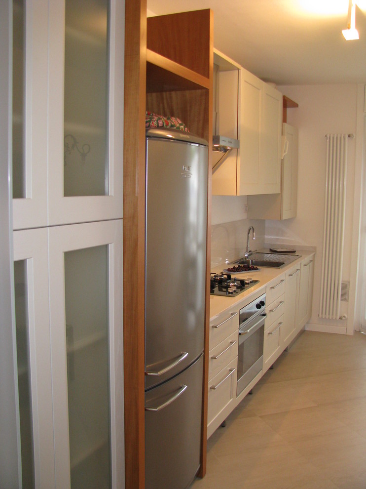 Example of a small trendy single-wall ceramic tile and beige floor enclosed kitchen design in Milan with a drop-in sink, recessed-panel cabinets, beige cabinets, quartz countertops, beige backsplash, marble backsplash and stainless steel appliances