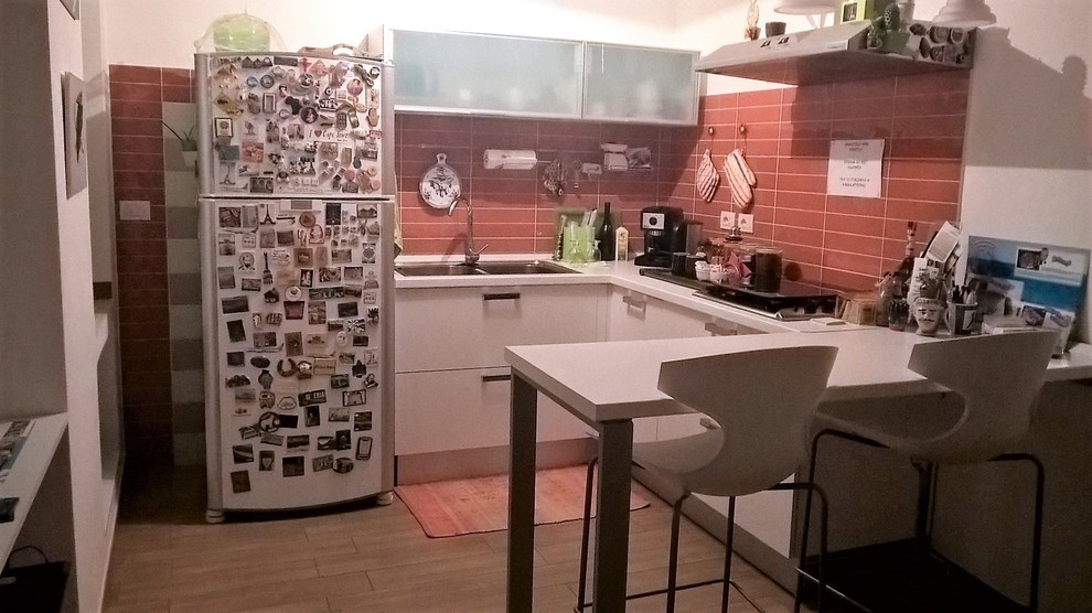 Immagine di una piccola cucina moderna con lavello a doppia vasca, ante lisce, top in laminato, paraspruzzi rosso, paraspruzzi con piastrelle in ceramica, elettrodomestici bianchi, pavimento con piastrelle in ceramica e ante in legno chiaro