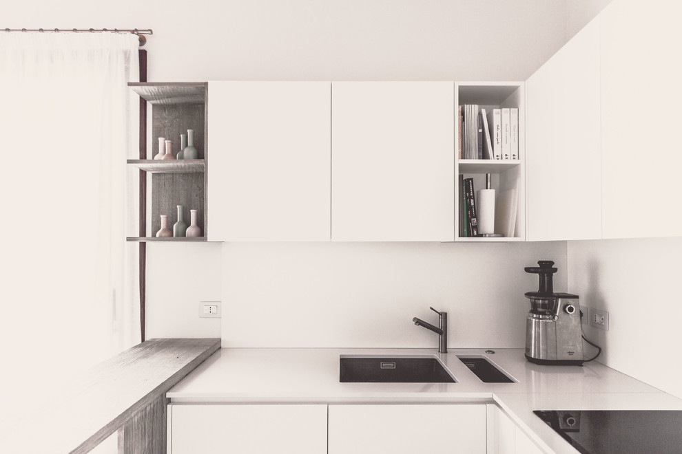Inspiration for a small modern u-shaped open plan kitchen in Milan with a submerged sink, flat-panel cabinets, white cabinets, quartz worktops, white splashback, stainless steel appliances, ceramic flooring, no island, grey floors and white worktops.