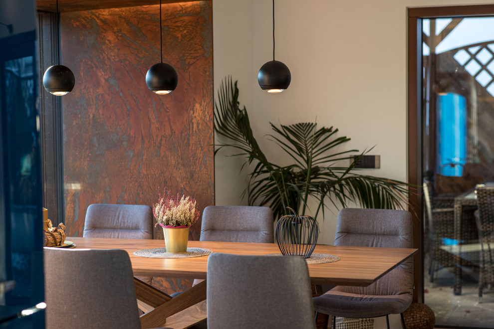 Foto di una grande sala da pranzo aperta verso la cucina minimalista con pavimento in legno verniciato e pavimento marrone