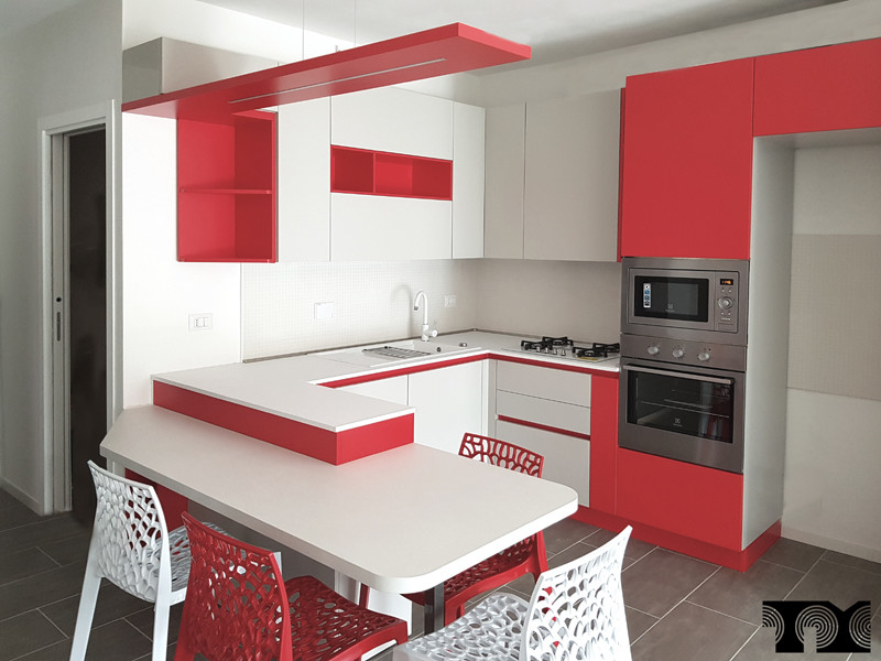 Design ideas for a medium sized modern u-shaped kitchen/diner in Bologna with a built-in sink, flat-panel cabinets, red cabinets, laminate countertops, white splashback, ceramic splashback, stainless steel appliances, porcelain flooring, a breakfast bar, grey floors and white worktops.