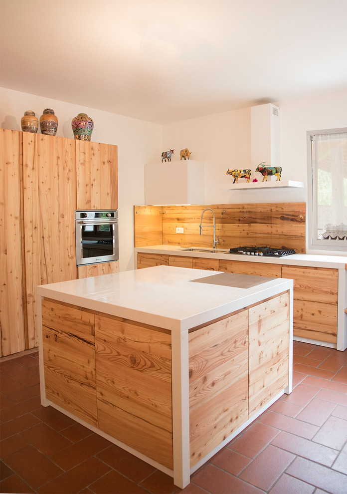Foto di una grande cucina nordica con ante lisce, ante in legno chiaro, pavimento in terracotta, lavello a doppia vasca, top in marmo, paraspruzzi bianco, paraspruzzi con lastra di vetro e elettrodomestici neri
