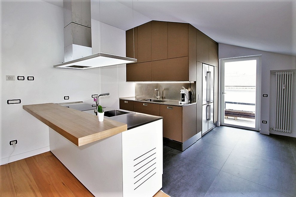 Example of a mid-sized trendy concrete floor and gray floor kitchen design in Milan with a single-bowl sink, flat-panel cabinets, brown cabinets, stainless steel countertops, metallic backsplash, paneled appliances and two islands