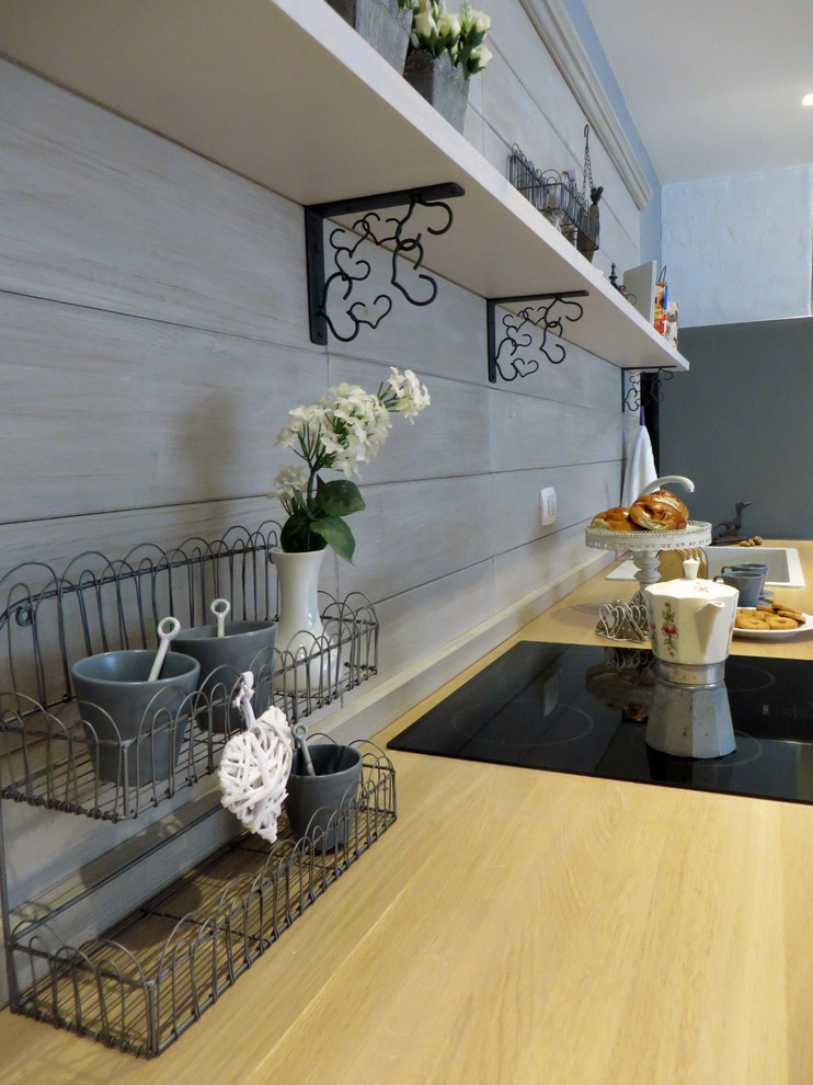 カターニア／パルレモにある広いシャビーシック調のおしゃれなキッチン (ガラス扉のキャビネット、木材カウンター、木材のキッチンパネル、磁器タイルの床、シングルシンク) の写真