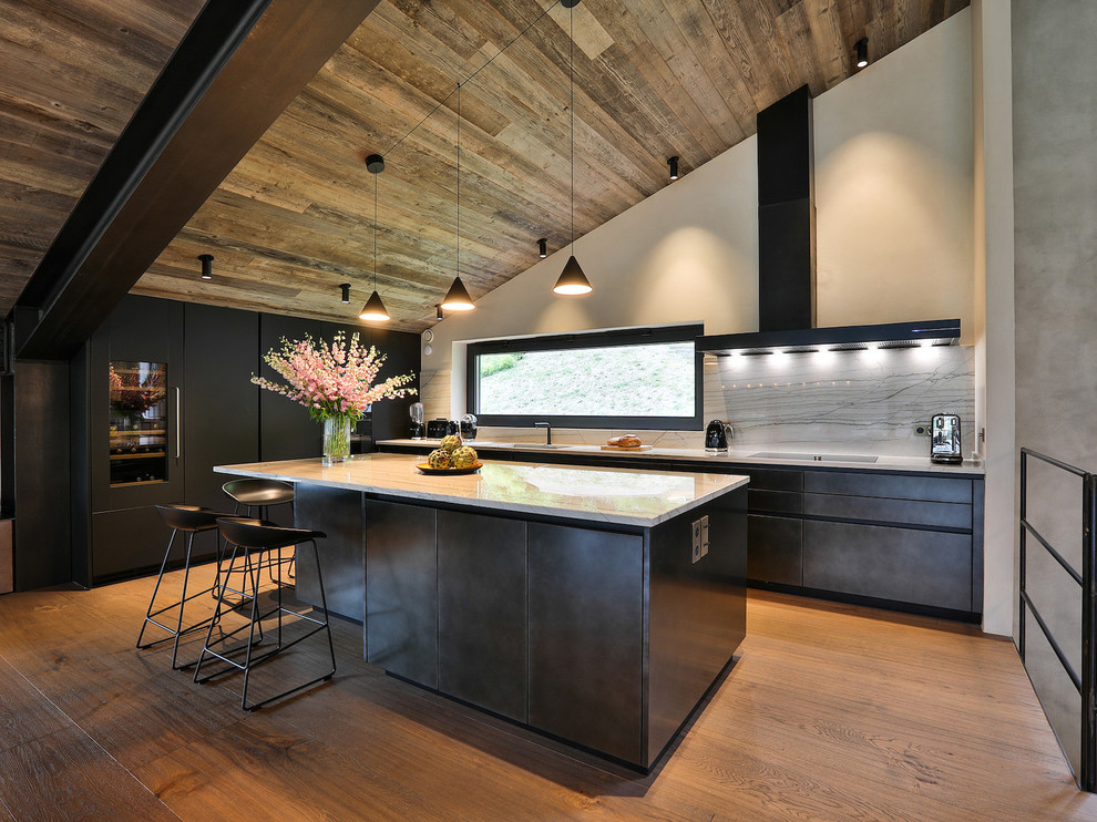 Inspiration for a rustic kitchen in Other with a single-bowl sink, flat-panel cabinets, black cabinets, grey splashback, stone slab splashback, integrated appliances, medium hardwood flooring, an island and grey worktops.