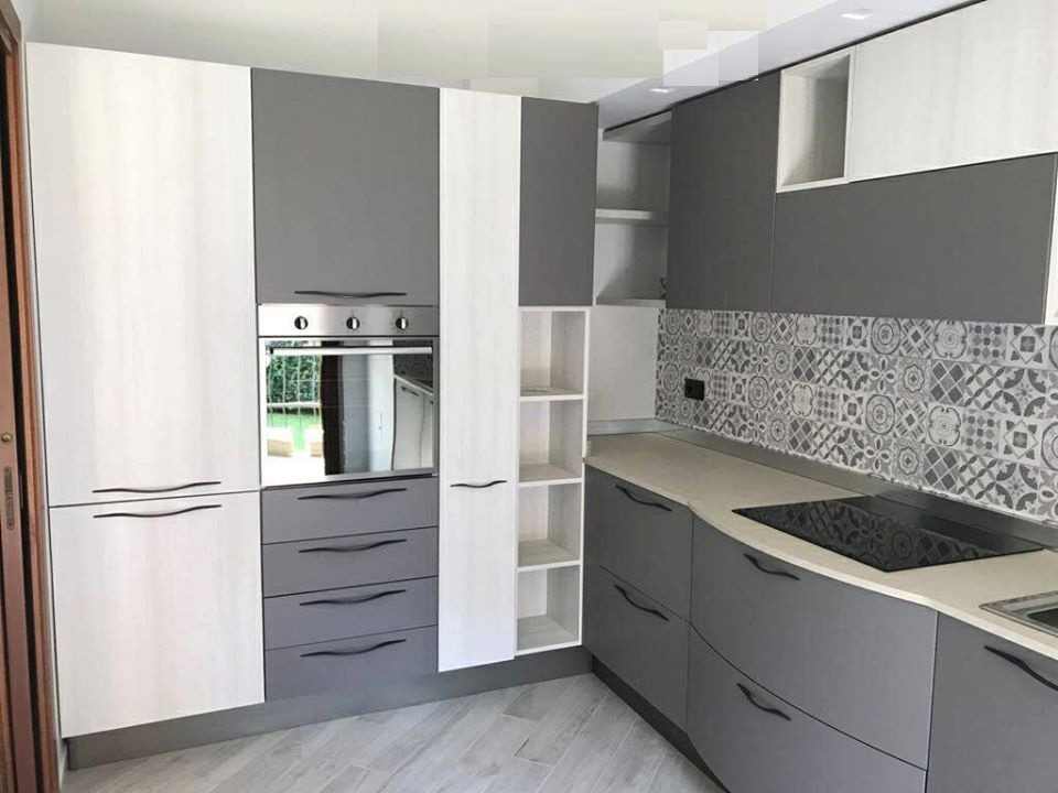 Photo of a medium sized modern l-shaped enclosed kitchen in Milan with a built-in sink, flat-panel cabinets, grey cabinets, laminate countertops, grey splashback, porcelain splashback, stainless steel appliances, porcelain flooring, no island, grey floors and grey worktops.