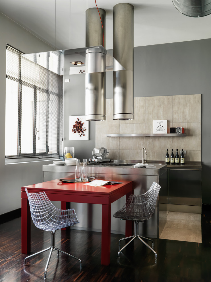 Example of a trendy single-wall dark wood floor and brown floor kitchen design in Milan with beige backsplash and stainless steel appliances