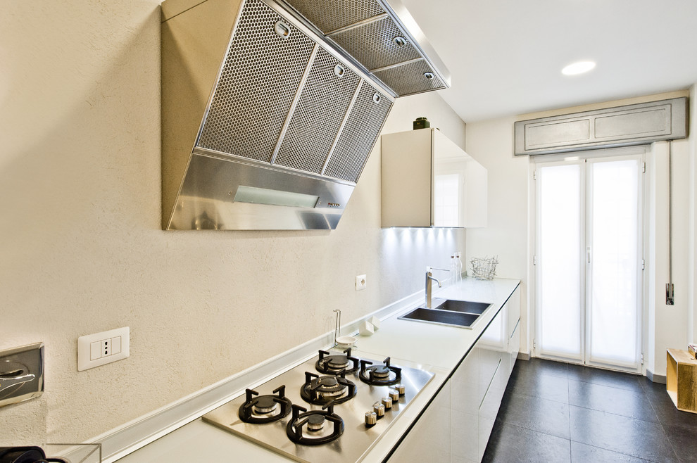 Immagine di una cucina industriale con lavello a doppia vasca, top in vetro, paraspruzzi grigio, pavimento in gres porcellanato, pavimento nero e top bianco