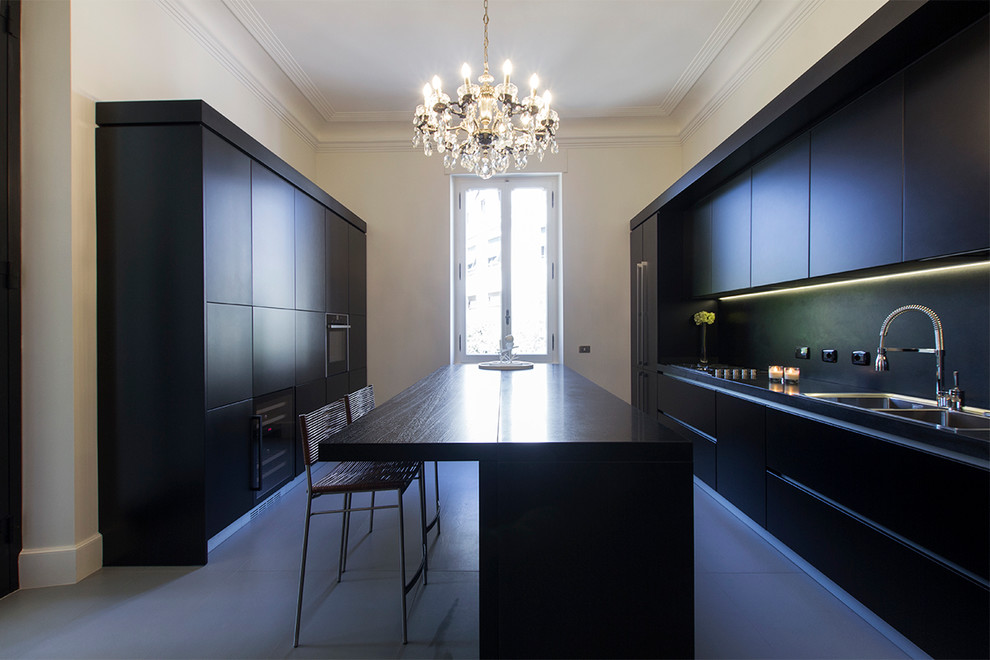 Immagine di una cucina design chiusa e di medie dimensioni con lavello a doppia vasca, ante lisce, ante nere, top in legno, paraspruzzi nero e elettrodomestici neri