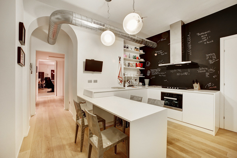 На фото: угловая кухня в современном стиле с плоскими фасадами, белыми фасадами, светлым паркетным полом и полуостровом