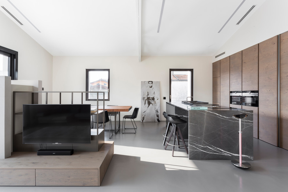Foto di una cucina design con pavimento grigio, ante lisce, ante in legno scuro, elettrodomestici neri, pavimento in cemento e top grigio