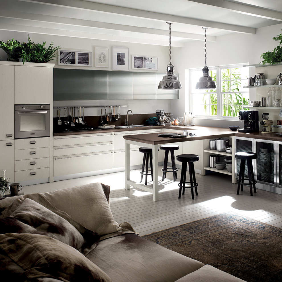 Foto di una grande cucina ad ambiente unico industriale con ante lisce, ante in legno chiaro, penisola e top marrone
