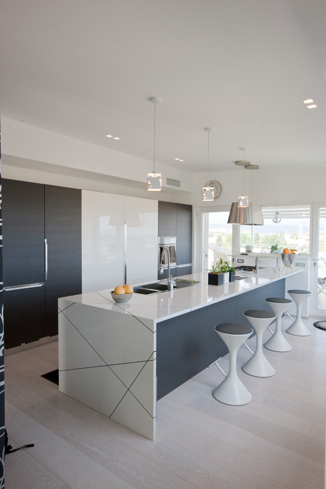 Photo of a large contemporary single-wall open plan kitchen in Other with a built-in sink, flat-panel cabinets, white cabinets, composite countertops, light hardwood flooring and an island.