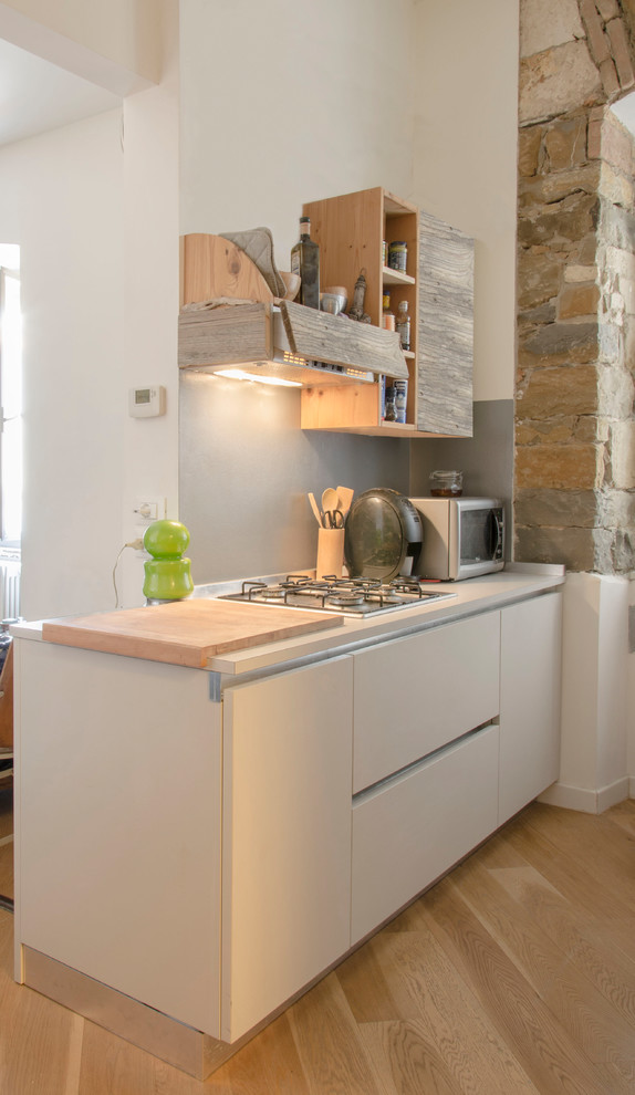 Стильный дизайн: параллельная кухня-гостиная в современном стиле с плоскими фасадами, серыми фасадами, деревянной столешницей и островом - последний тренд