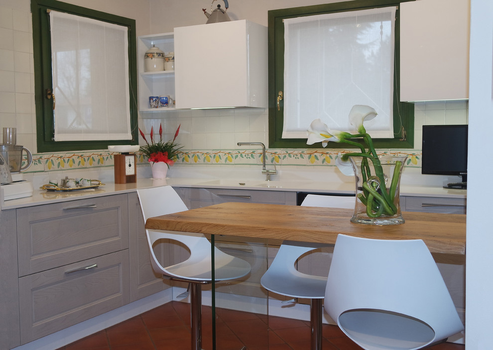 Ispirazione per una cucina minimalista chiusa e di medie dimensioni con lavello integrato, ante lisce, ante in legno chiaro, top in quarzite, elettrodomestici bianchi, pavimento in terracotta, pavimento rosso e top bianco