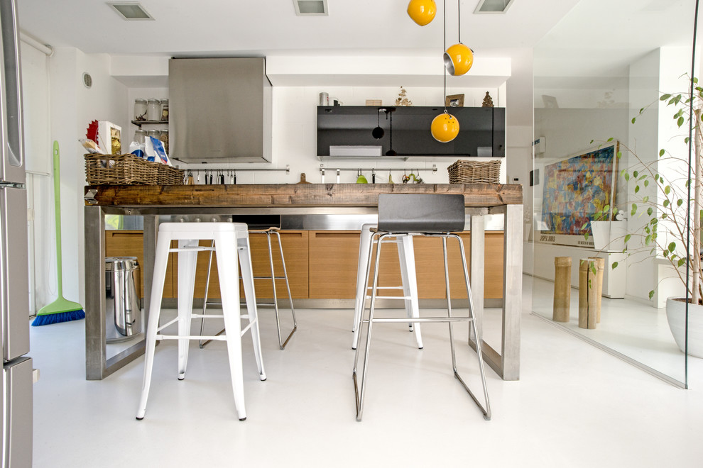 Inspiration for a mid-sized modern galley concrete floor open concept kitchen remodel in Catania-Palermo with a drop-in sink, flat-panel cabinets, black cabinets and stainless steel countertops