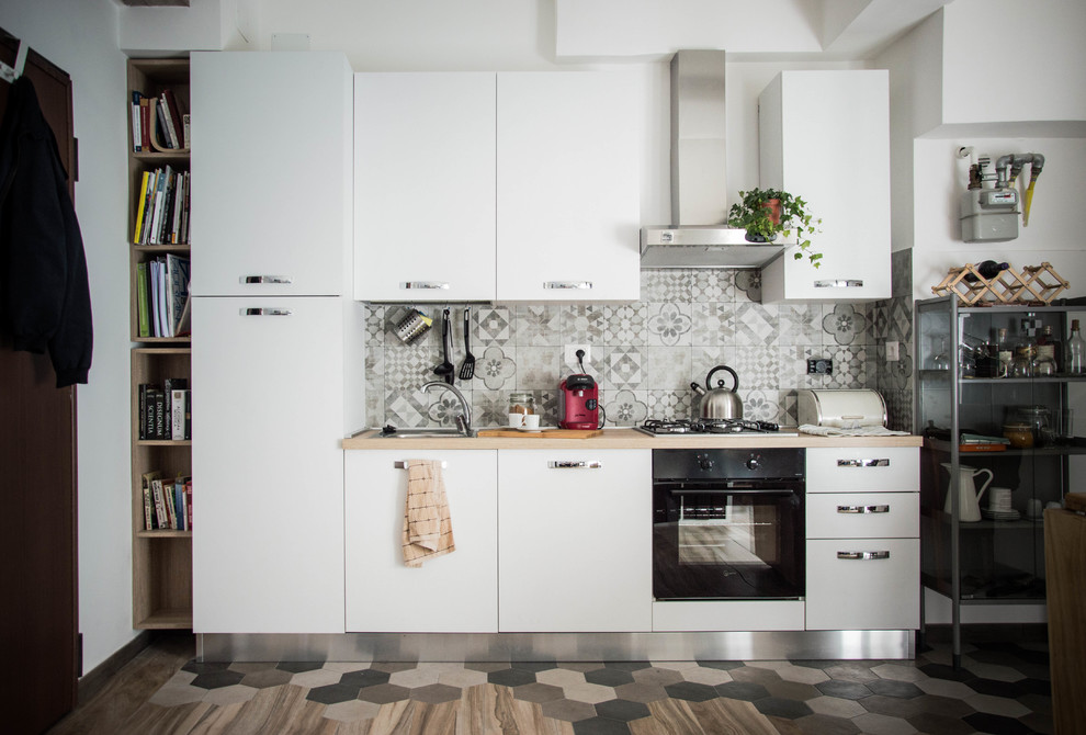 Foto på ett litet funkis linjärt kök och matrum, med stänkskydd i porslinskakel, rostfria vitvaror och klinkergolv i porslin