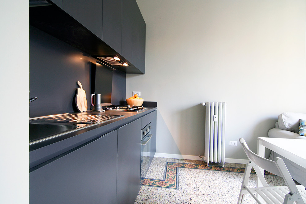 На фото: прямая кухня в современном стиле с обеденным столом, одинарной мойкой, серыми фасадами, столешницей из ламината, серым фартуком и техникой из нержавеющей стали