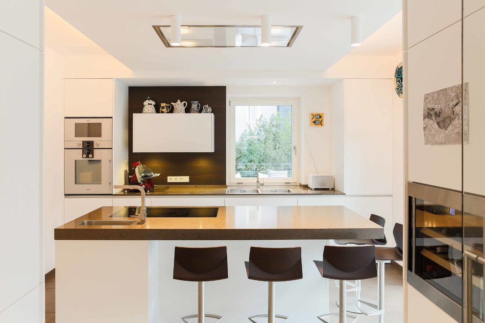 Exempel på ett stort modernt linjärt kök, med släta luckor, vita skåp, en köksö, en undermonterad diskho, bänkskiva i betong och rostfria vitvaror
