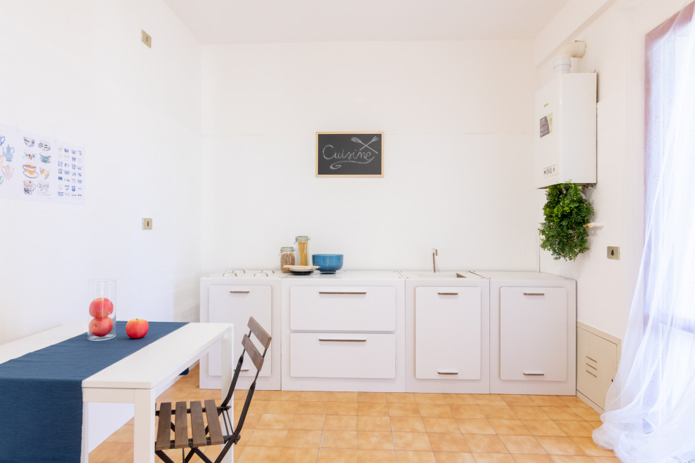 Foto di una cucina minimalista di medie dimensioni con lavello da incasso, nessun'anta, ante bianche, paraspruzzi bianco, pavimento in gres porcellanato, penisola, pavimento beige e top bianco