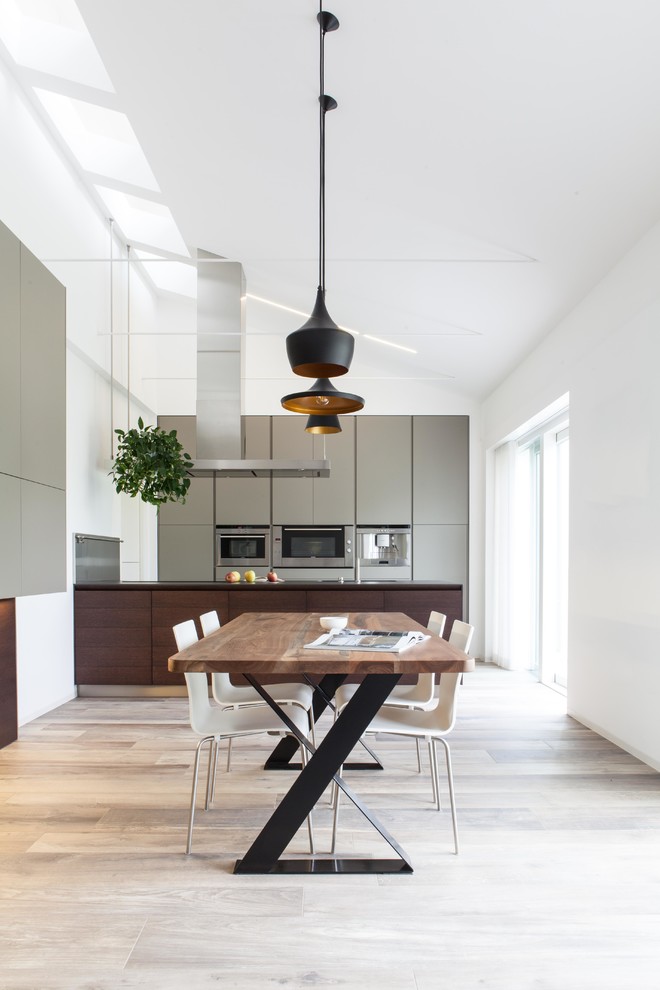 Immagine di una grande cucina moderna con ante lisce, ante in legno bruno, elettrodomestici in acciaio inossidabile, pavimento in legno massello medio e penisola