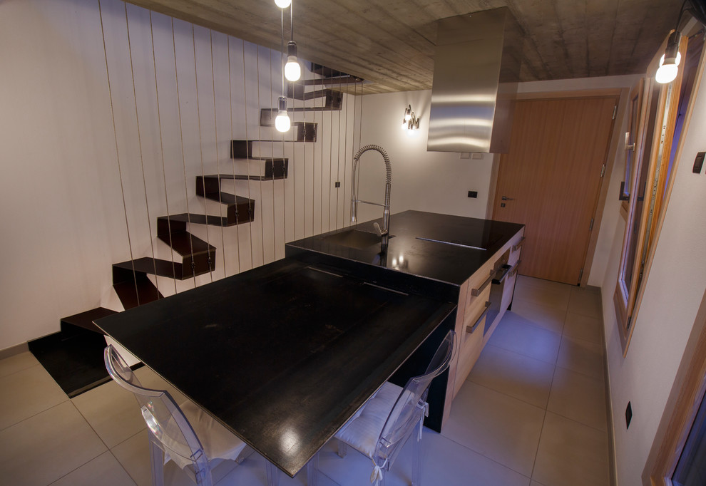 Foto di una piccola cucina moderna con lavello sottopiano, ante lisce, ante in legno chiaro, top in superficie solida, elettrodomestici in acciaio inossidabile, pavimento in gres porcellanato e pavimento grigio
