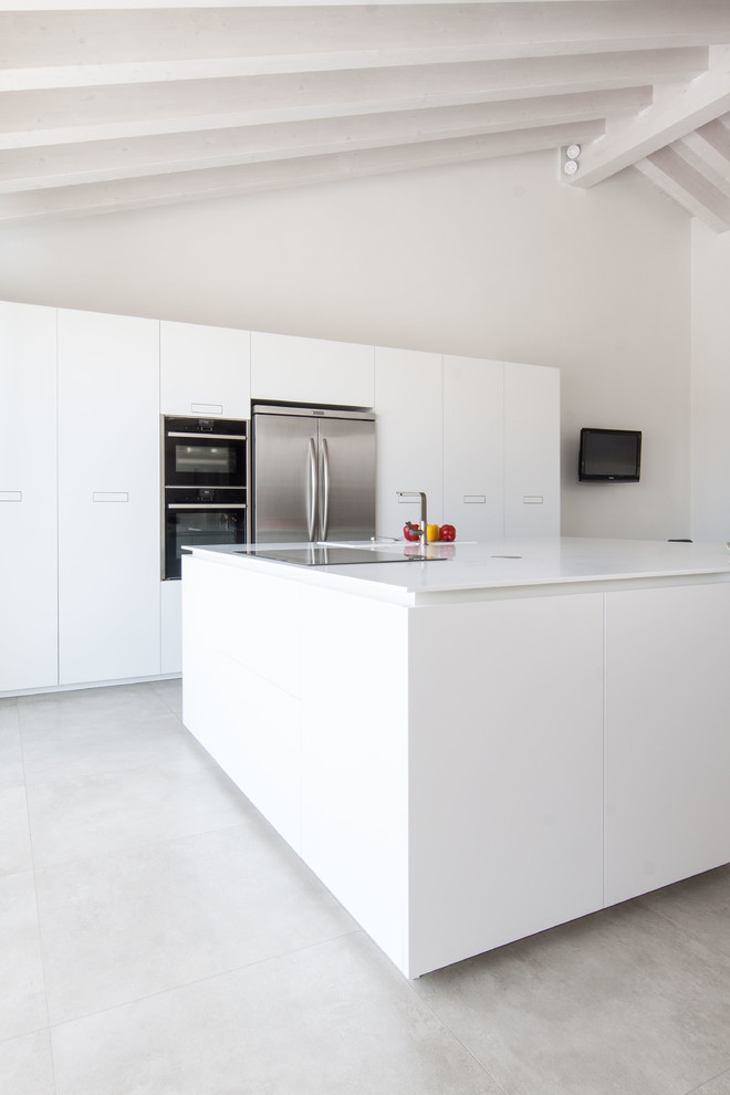 Photo of a medium sized modern single-wall open plan kitchen in Venice with flat-panel cabinets, white cabinets, engineered stone countertops, stainless steel appliances and an island.