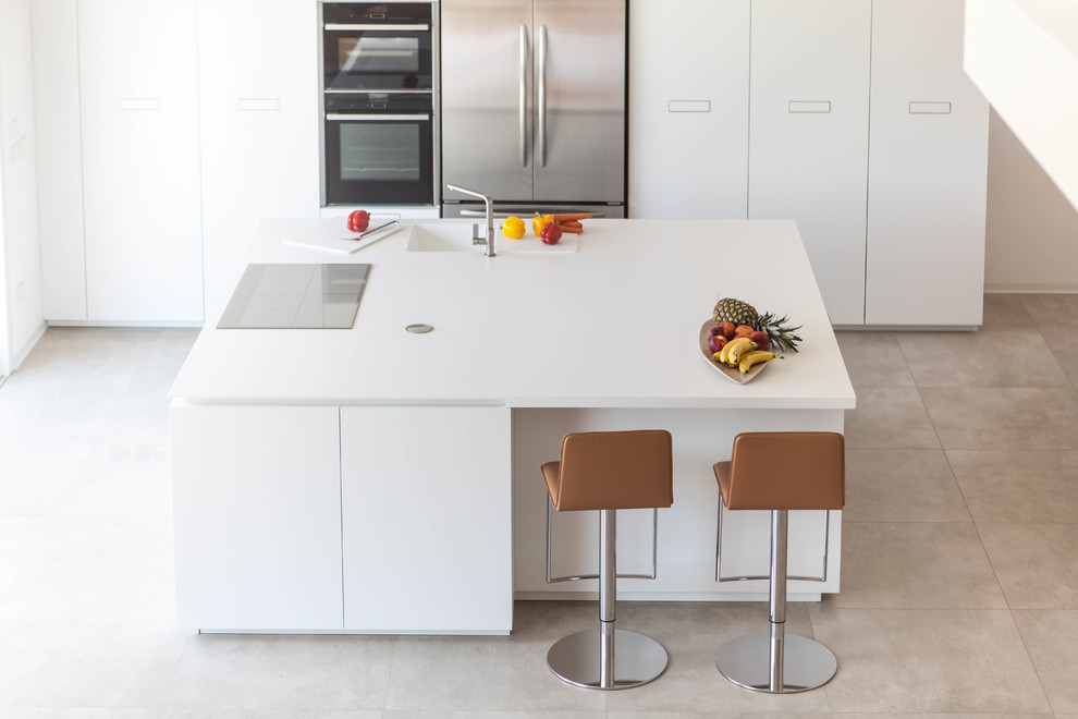 Foto de cocina lineal minimalista de tamaño medio abierta con armarios con paneles lisos, puertas de armario blancas, encimera de cuarzo compacto, electrodomésticos de acero inoxidable y una isla
