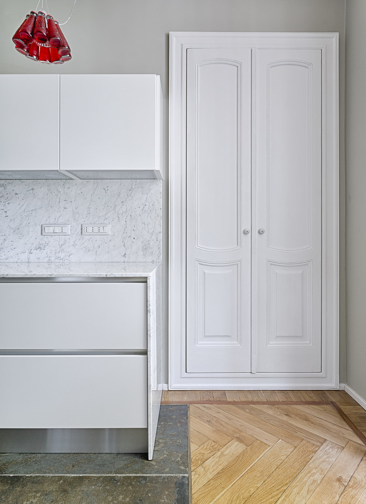 Imagen de cocina contemporánea con puertas de armario blancas y una isla