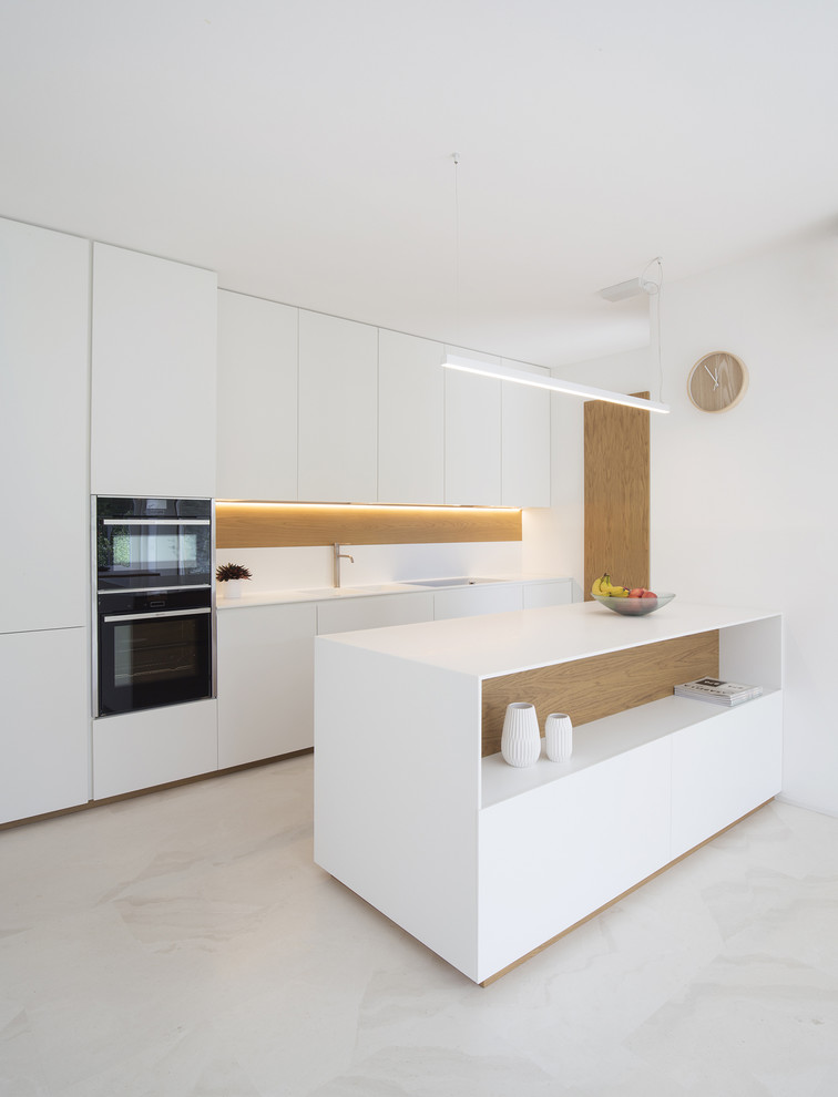 Exemple d'une cuisine ouverte linéaire tendance de taille moyenne avec un placard à porte plane, des portes de placard blanches, un électroménager noir, une péninsule et un sol blanc.