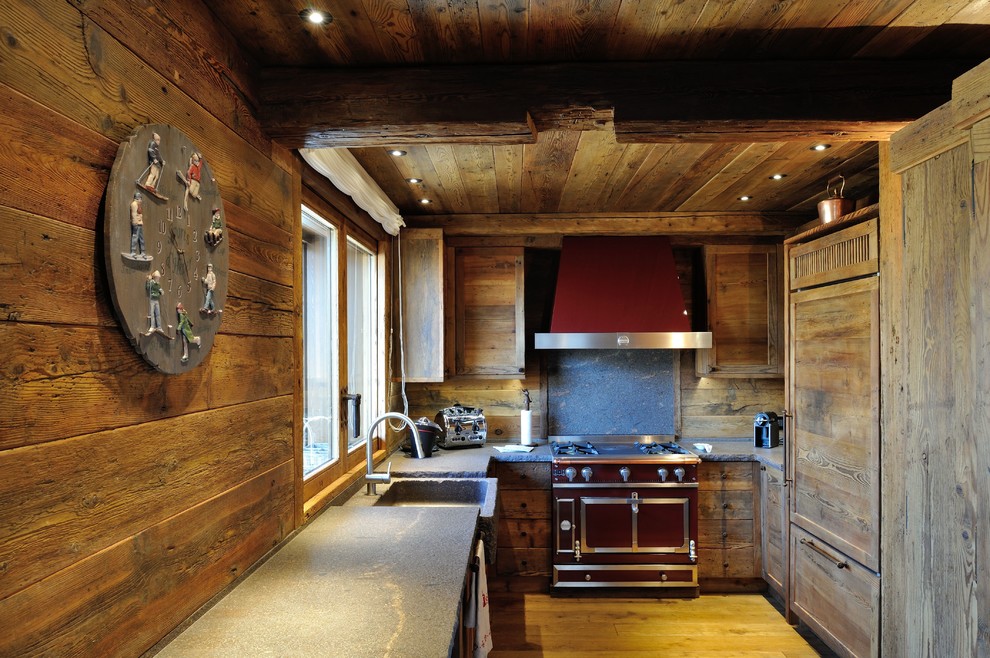 Immagine di una cucina ad U rustica con lavello stile country, ante in legno scuro, elettrodomestici colorati, pavimento in legno massello medio e nessuna isola