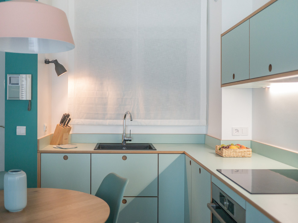 Photo of a small contemporary l-shaped open plan kitchen in Milan with a single-bowl sink, flat-panel cabinets, green cabinets, laminate countertops, white splashback, stainless steel appliances, lino flooring, no island and green worktops.