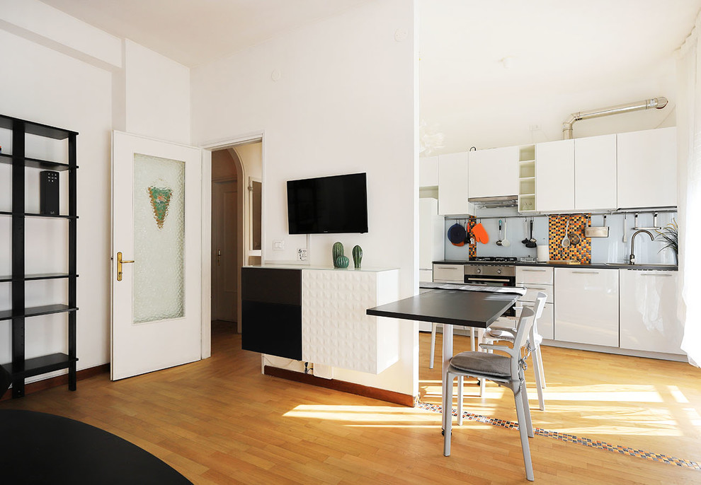 Пример оригинального дизайна: кухня-гостиная в стиле лофт с накладной мойкой, плоскими фасадами, разноцветным фартуком, техникой из нержавеющей стали, светлым паркетным полом, черной столешницей и черно-белыми фасадами