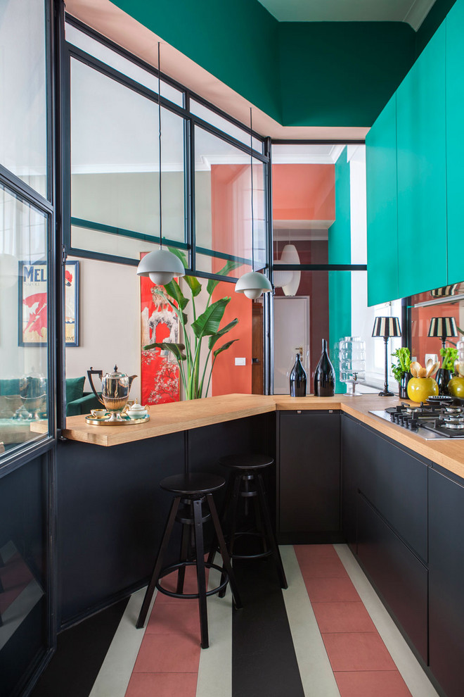ミラノにあるコンテンポラリースタイルのおしゃれなキッチン (フラットパネル扉のキャビネット、黒いキャビネット、木材カウンター、マルチカラーの床、茶色いキッチンカウンター) の写真