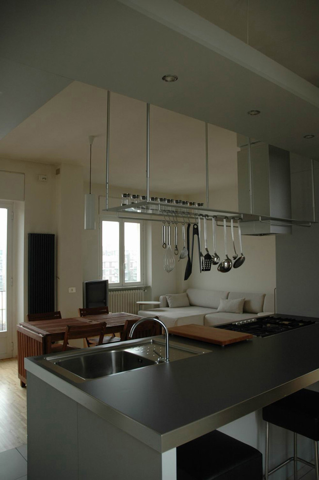 Example of a mid-sized trendy porcelain tile eat-in kitchen design in Milan with a single-bowl sink, flat-panel cabinets, gray cabinets, laminate countertops, paneled appliances and an island