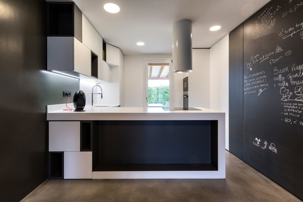 Esempio di una cucina minimal con ante lisce, ante bianche, pavimento in cemento, penisola, pavimento grigio e top bianco