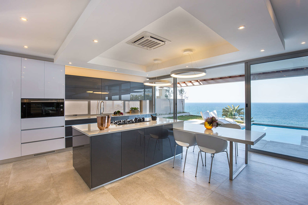 Свежая идея для дизайна: прямая кухня в современном стиле с обеденным столом, серыми фасадами, островом и белой столешницей - отличное фото интерьера