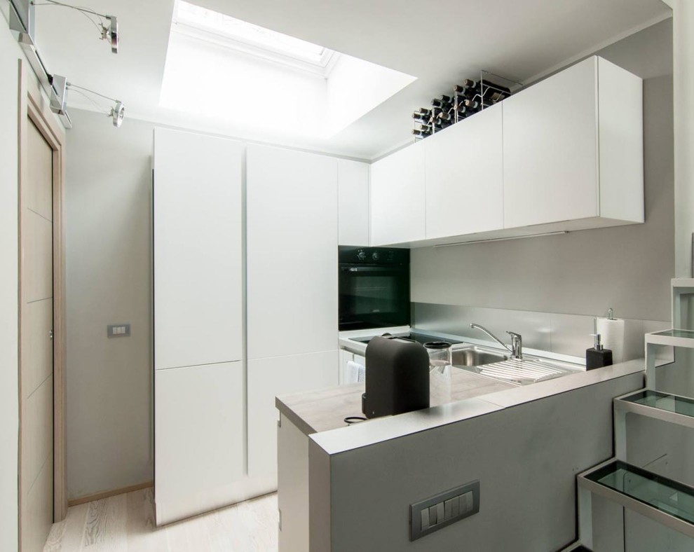 Esempio di una piccola cucina moderna con paraspruzzi grigio, nessuna isola e pavimento marrone