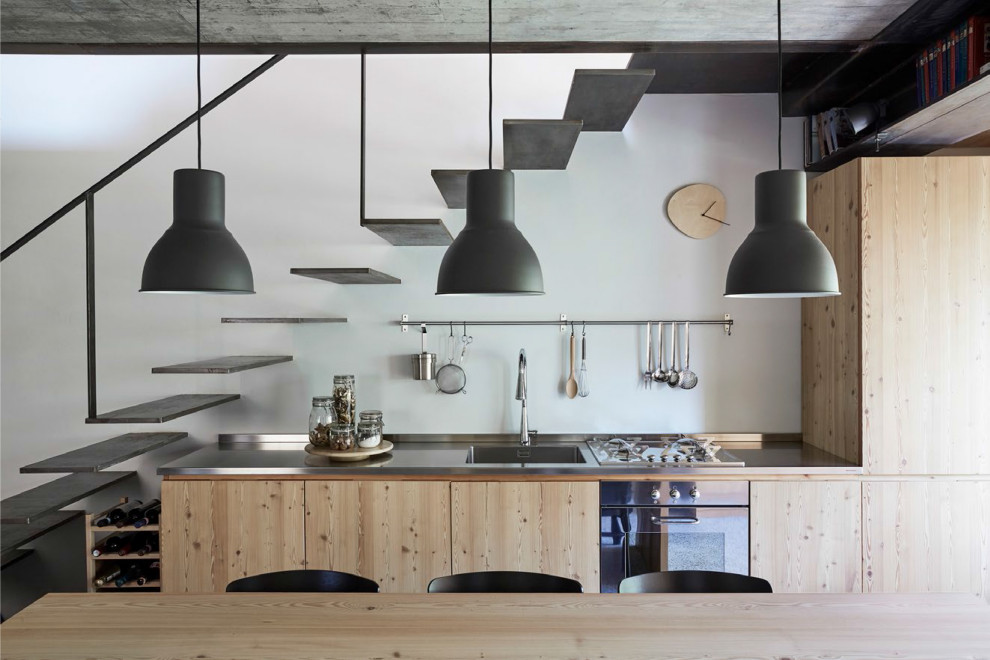 Industriell inredning av ett litet grå linjärt grått kök och matrum, med en integrerad diskho, släta luckor, beige skåp, bänkskiva i rostfritt stål och integrerade vitvaror