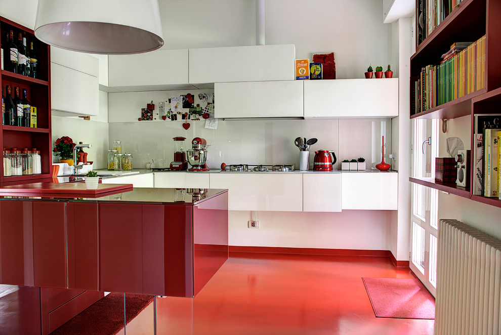 Immagine di una cucina ad U minimal di medie dimensioni con ante lisce, ante rosse, paraspruzzi bianco, penisola, pavimento rosso e paraspruzzi con lastra di vetro