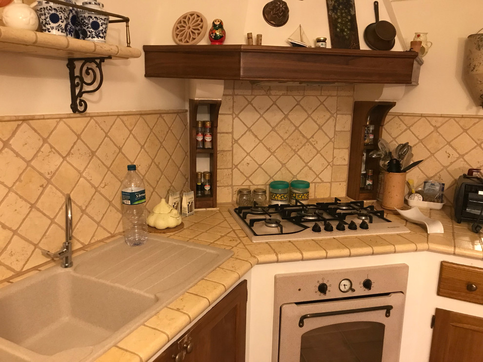 Mid-sized cottage l-shaped porcelain tile and pink floor open concept kitchen photo in Other with a double-bowl sink, raised-panel cabinets, medium tone wood cabinets, marble countertops, beige backsplash, marble backsplash, paneled appliances and beige countertops