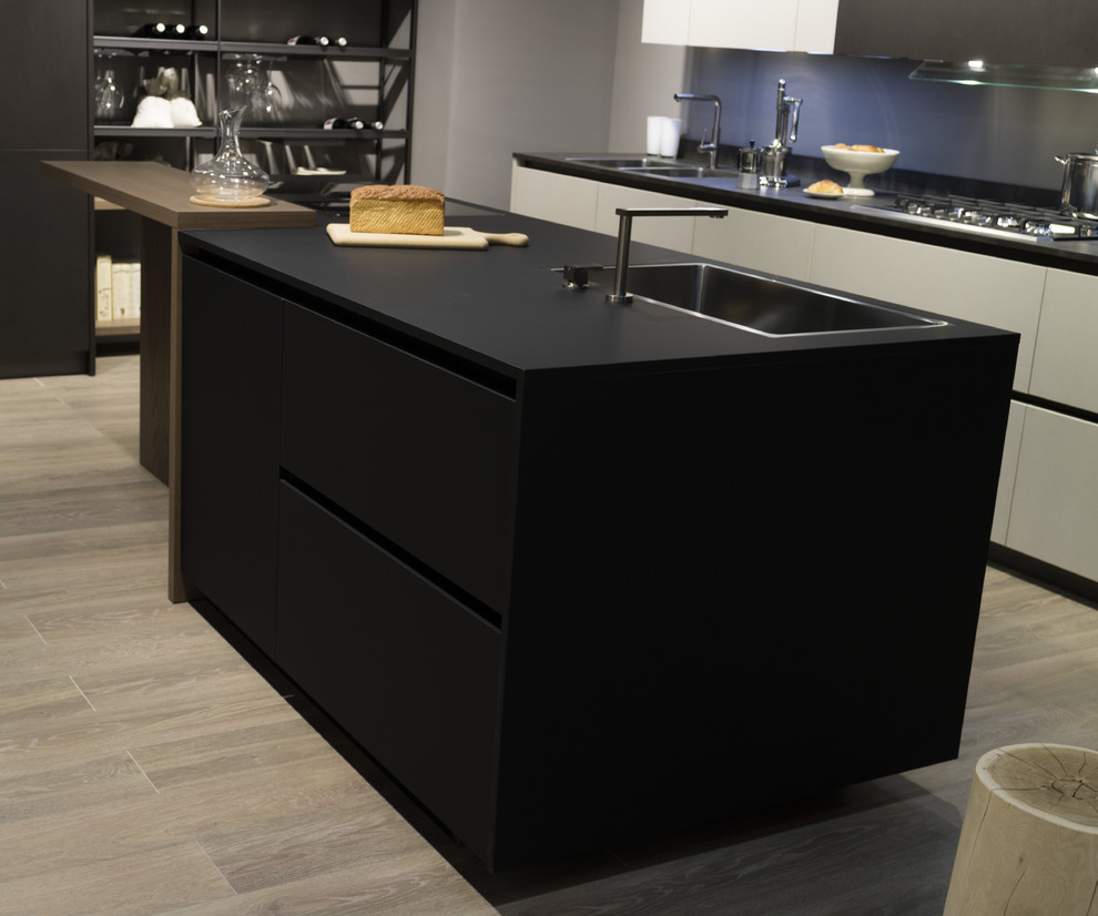 Esempio di una cucina moderna di medie dimensioni con lavello da incasso, ante lisce, ante nere, paraspruzzi grigio, elettrodomestici in acciaio inossidabile e pavimento in bambù