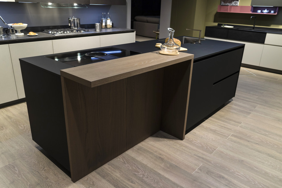 This is an example of a medium sized modern single-wall open plan kitchen in Naples with a built-in sink, flat-panel cabinets, black cabinets, grey splashback, stainless steel appliances, bamboo flooring and an island.