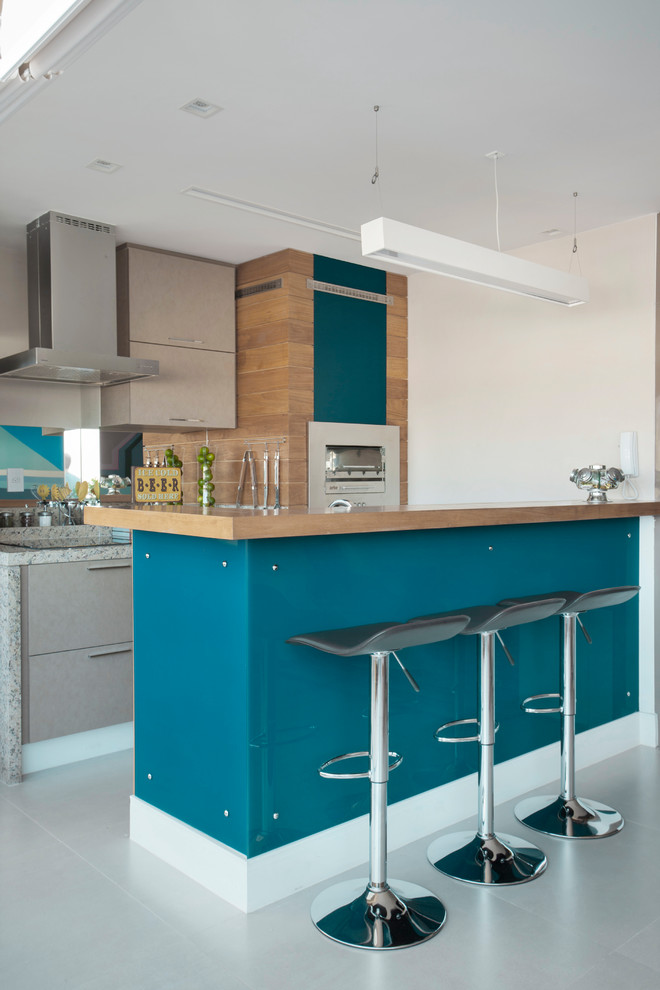 Foto di una cucina design con ante lisce, ante beige, top in granito, paraspruzzi a specchio, elettrodomestici in acciaio inossidabile e pavimento grigio